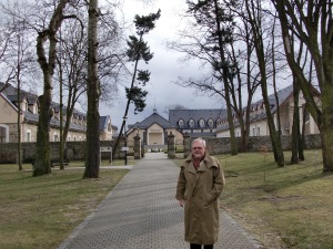 Hubertus Janas steht unter Bäumen vor dem Eingang zu einem Sanatorium.